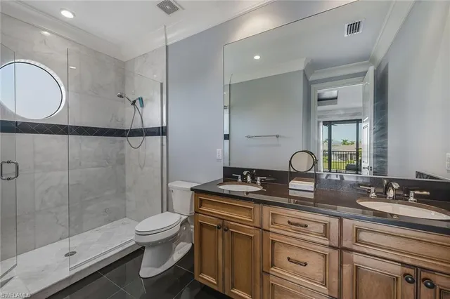 a bathroom with a granite countertop toilet sink shower and mirror