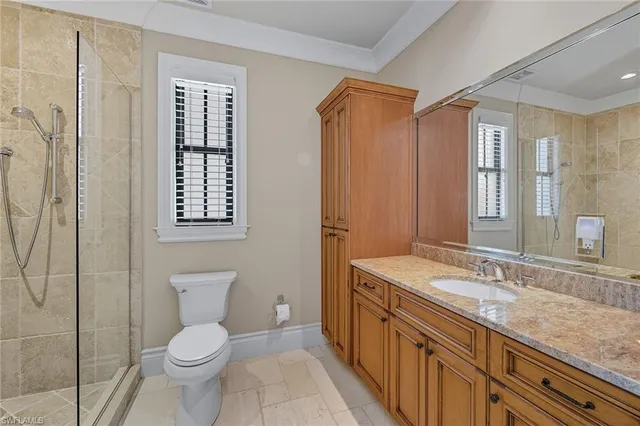 a bathroom with a granite countertop sink toilet and shower