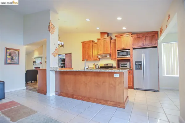 a kitchen with stainless steel appliances granite countertop a sink a stove and a refrigerator