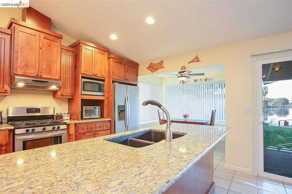 a kitchen with stainless steel appliances granite countertop a sink refrigerator and cabinets