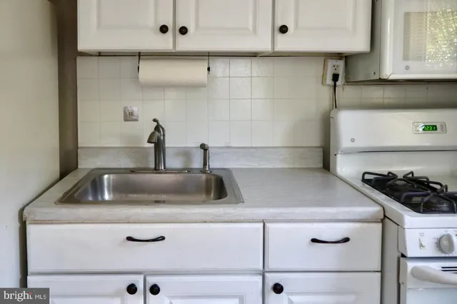 a kitchen with white cabinets and a sink