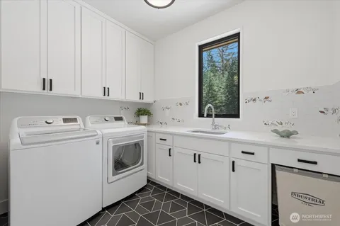 a utility room with cabinets washer and dryer