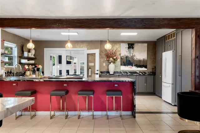 a kitchen with stainless steel appliances kitchen island granite countertop a table chairs in it and a window