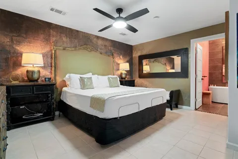 a bedroom with a bed and a ceiling fan