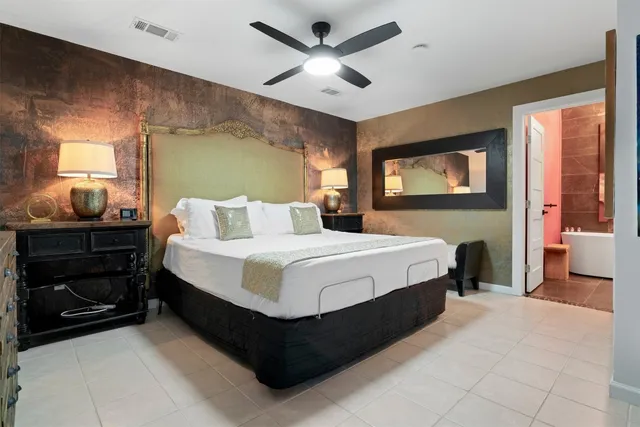 a bedroom with a bed and a ceiling fan