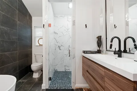 a bathroom with a sink a toilet and shower