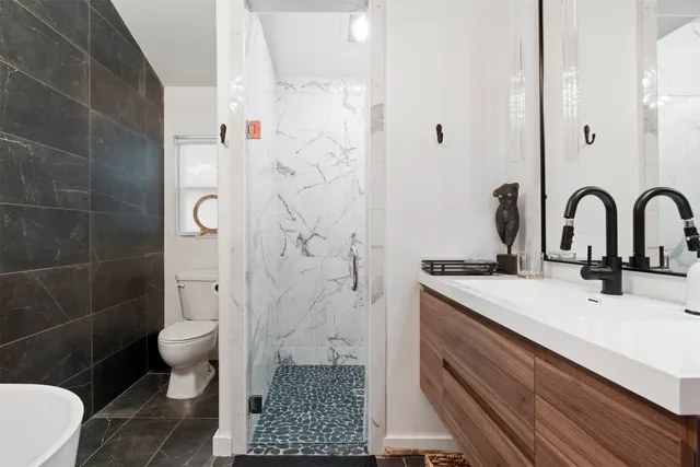 a bathroom with a sink a toilet and shower