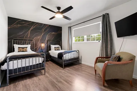 a bedroom with bed chair and window