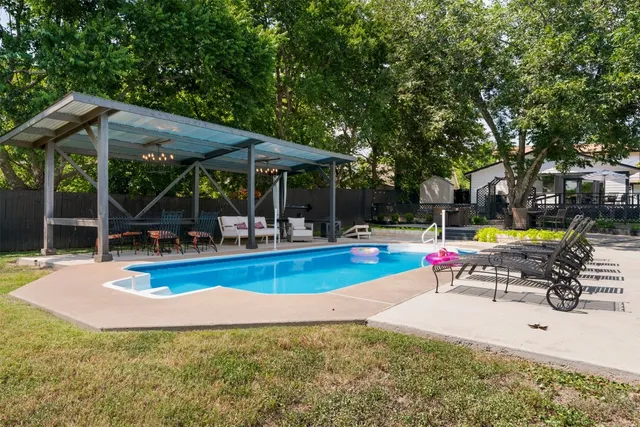 a view of a swimming pool with sitting area and roof