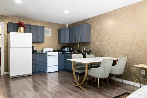 a kitchen with a table chairs refrigerator and cabinets