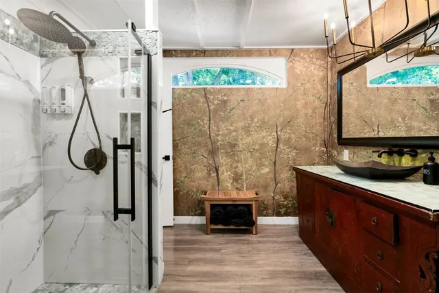 a spacious bathroom with a granite countertop sink a mirror and shower