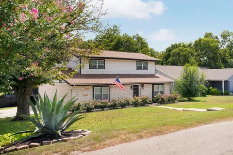 a front view of a house with a yard and trees