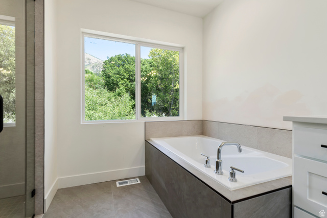 504 North 650 E Street Springville, UT 84663 - Photo 18 of 36 Built-in soaking tub with chrome fixtures, surrounded by neutral-toned wall tiling and a white window frame