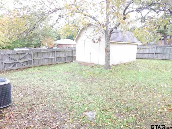 a view of a yard with a house and a large tree