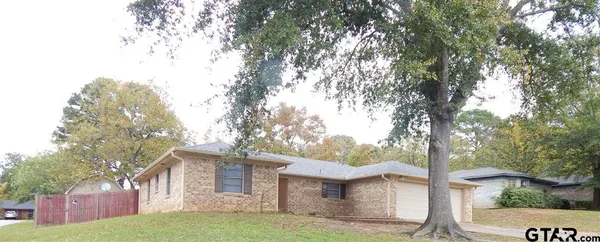 a view of a yard in front of a house with large tree