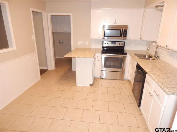 a kitchen with a stove top oven and cabinets