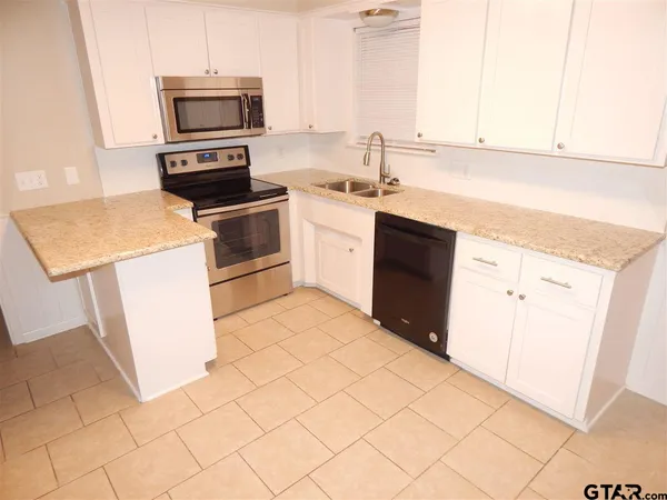 a kitchen with a sink a stove and cabinets