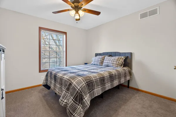 a bedroom with a bed and painting on the wall