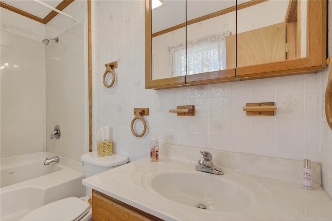 62 Stoney Road Tamaqua, PA 18252 - Photo 42 of 61 White tiled walls and wooden accents define this well-appointed bathroom space.