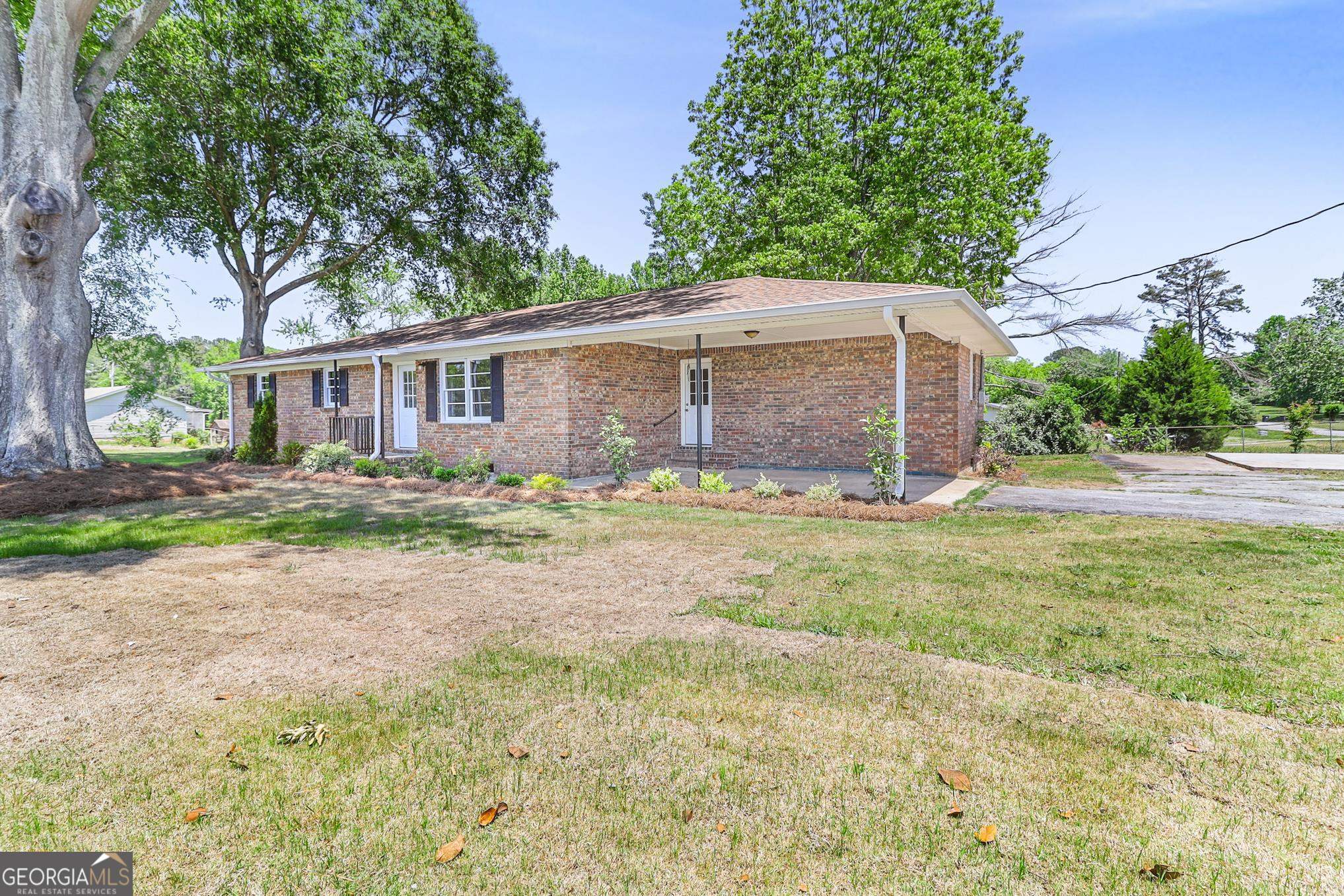 55 Welcome Sargent Road Newnan, GA 30263 - Photo 3 of 20 a front view of house with yard and trees around