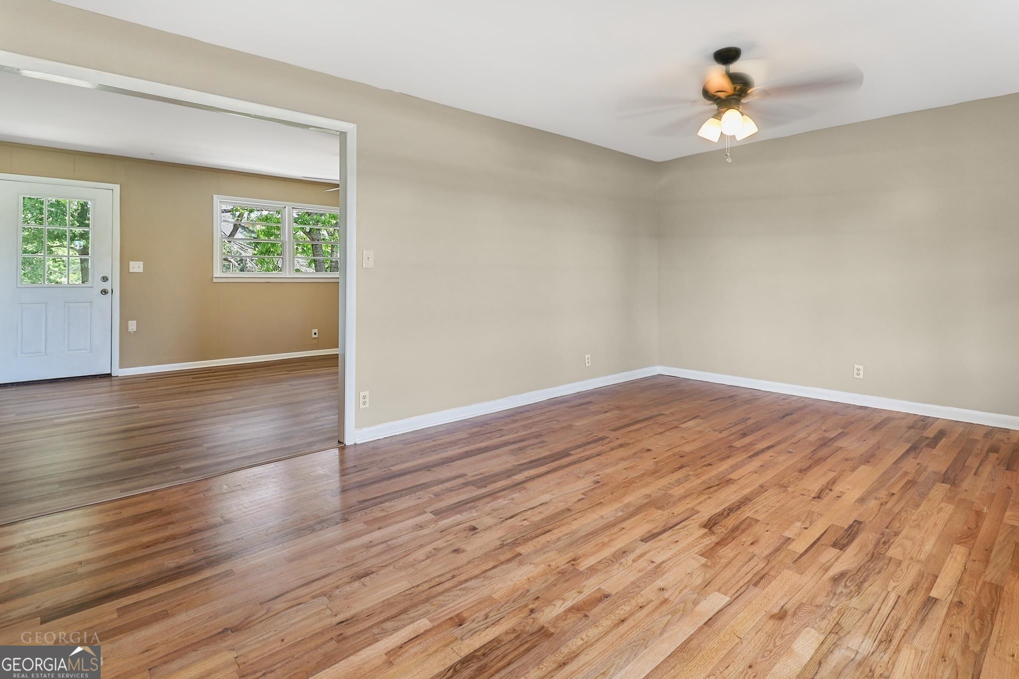 55 Welcome Sargent Road Newnan, GA 30263 - Photo 5 of 20 an empty room with wooden floor chandelier fan and windows