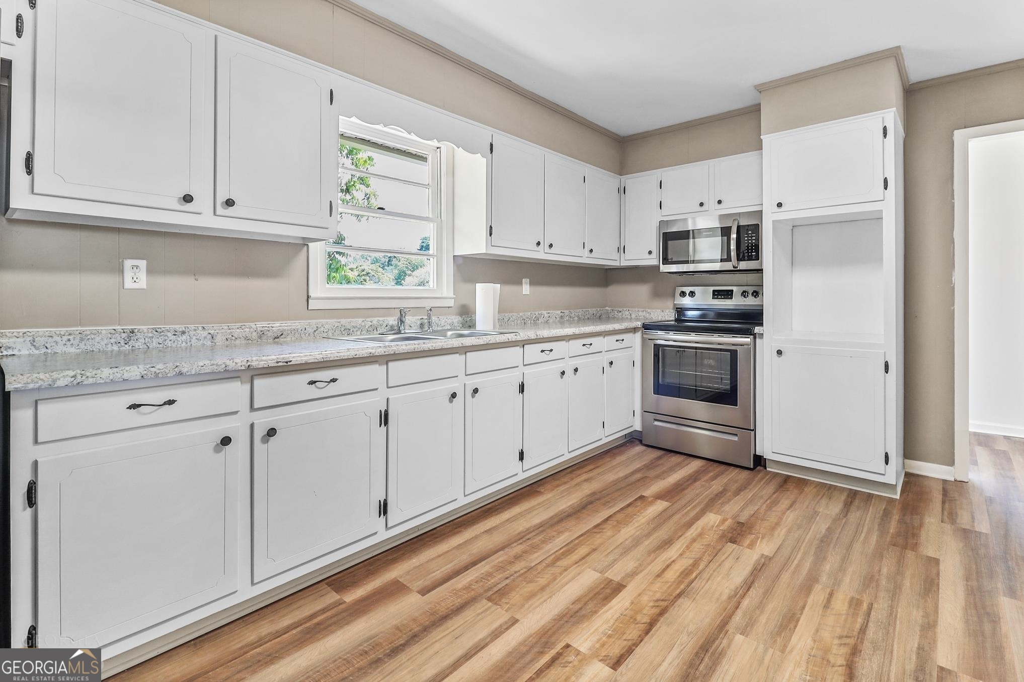55 Welcome Sargent Road Newnan, GA 30263 - Photo 8 of 20 a kitchen with stainless steel appliances granite countertop a stove a sink and white cabinets