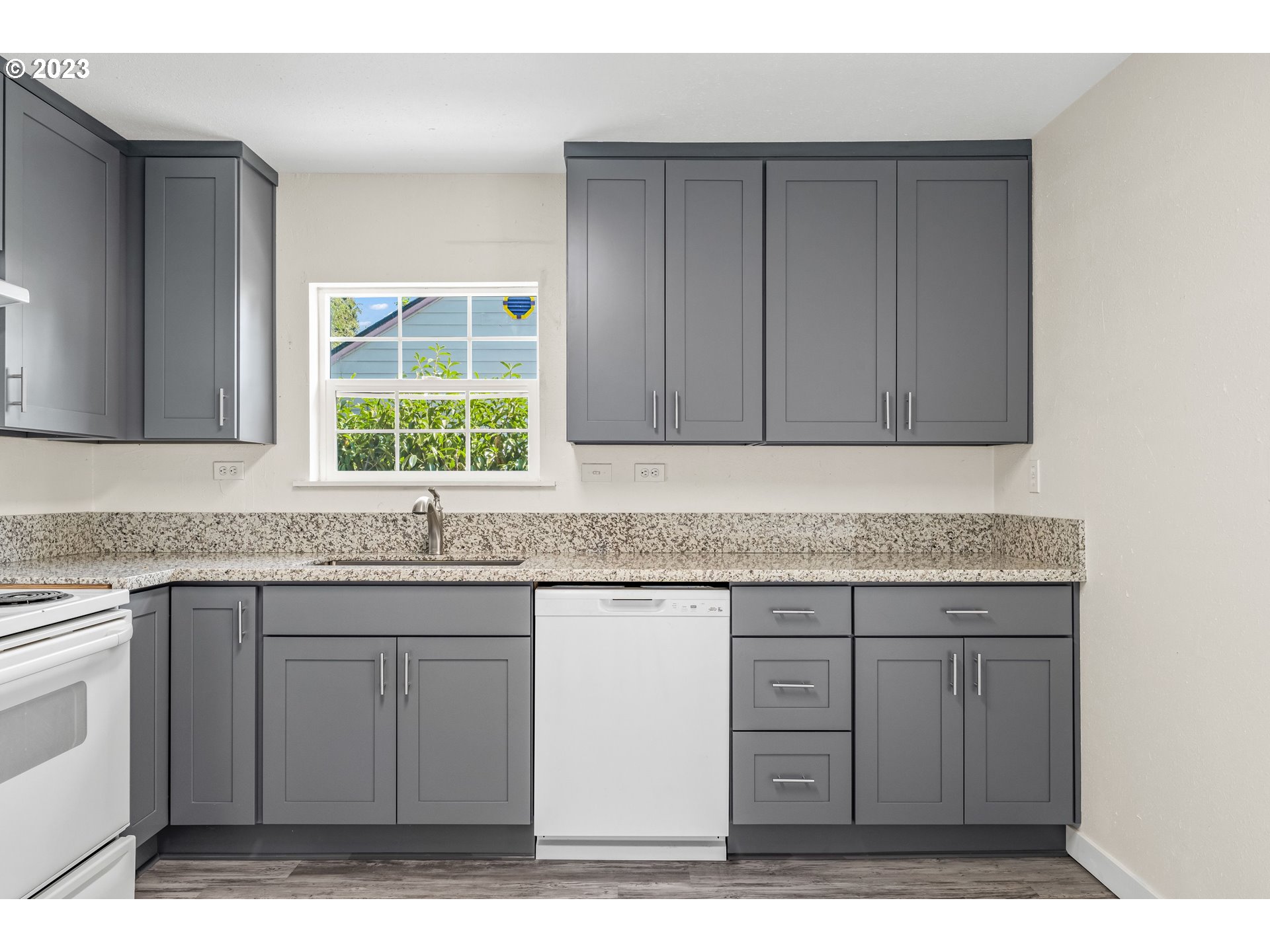 835 L Street Springfield, OR 97477 - Photo 11 of 40 a kitchen with granite countertop a sink cabinets and a window