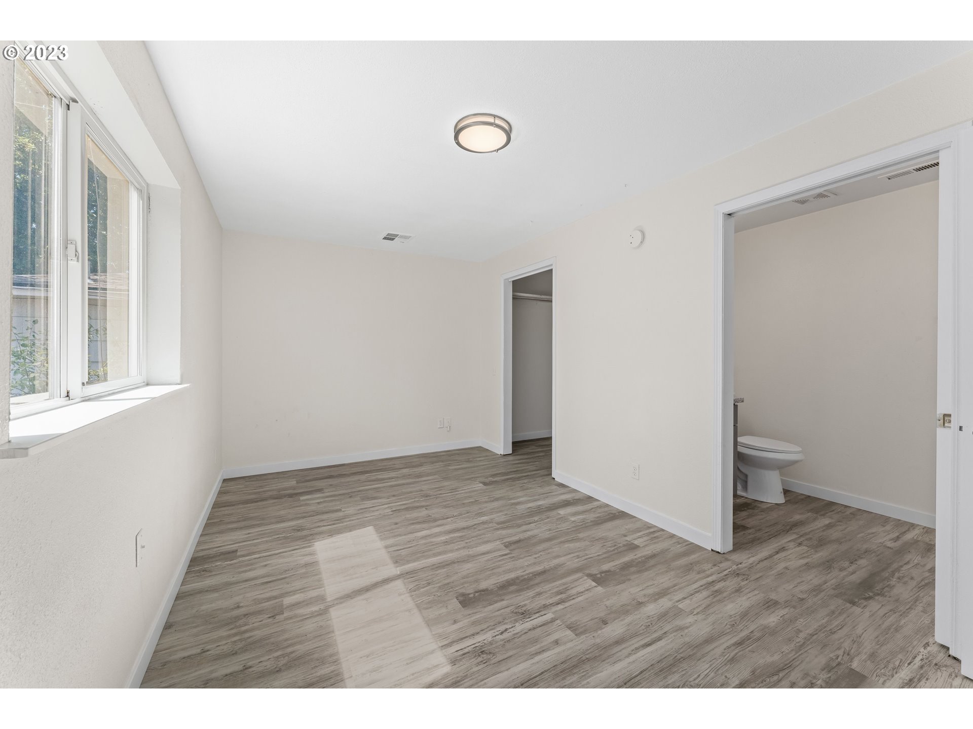 835 L Street Springfield, OR 97477 - Photo 18 of 40 a view of an empty room with wooden floor and a window
