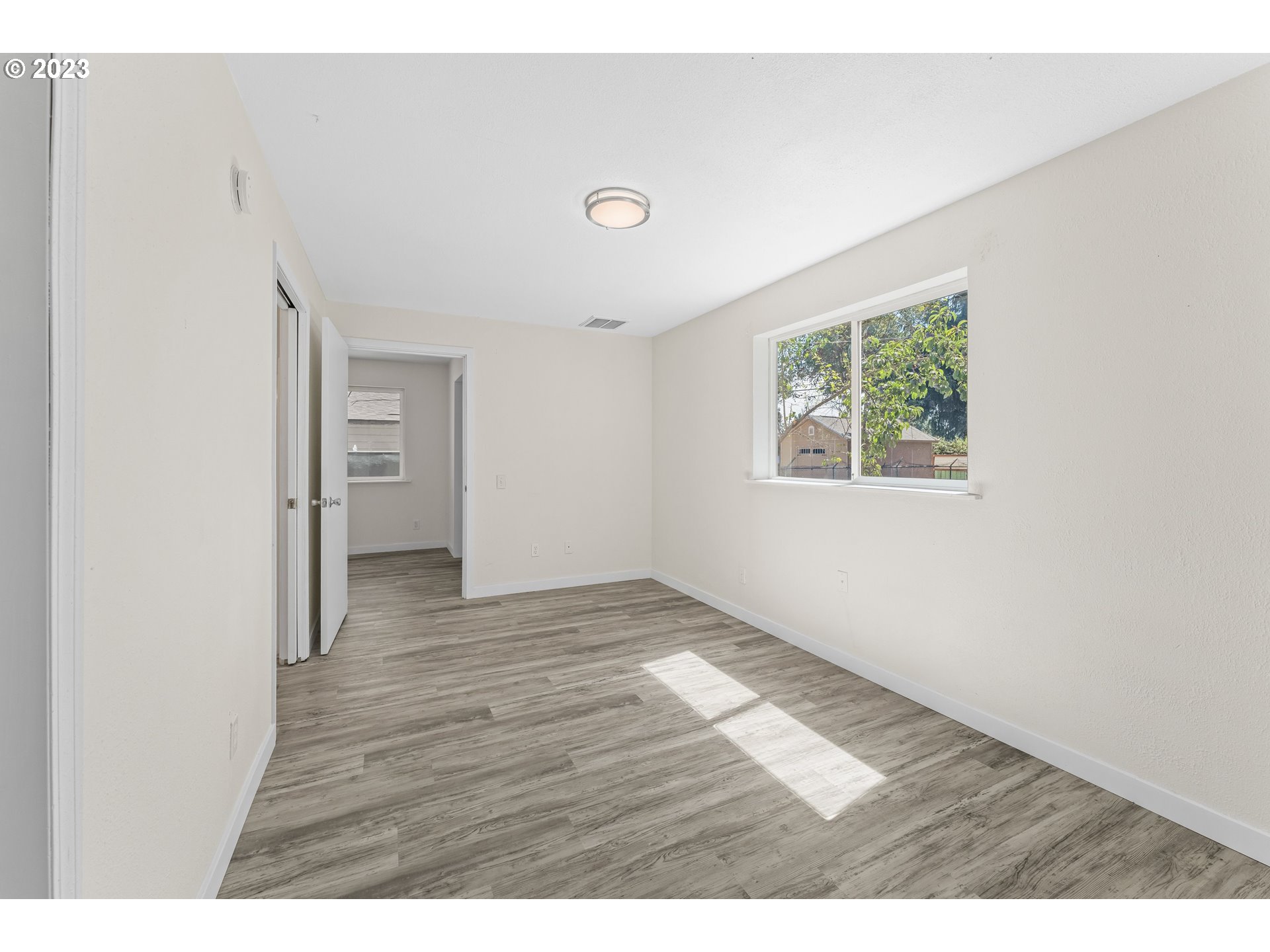 835 L Street Springfield, OR 97477 - Photo 20 of 40 a view of an empty room with wooden floor and a window