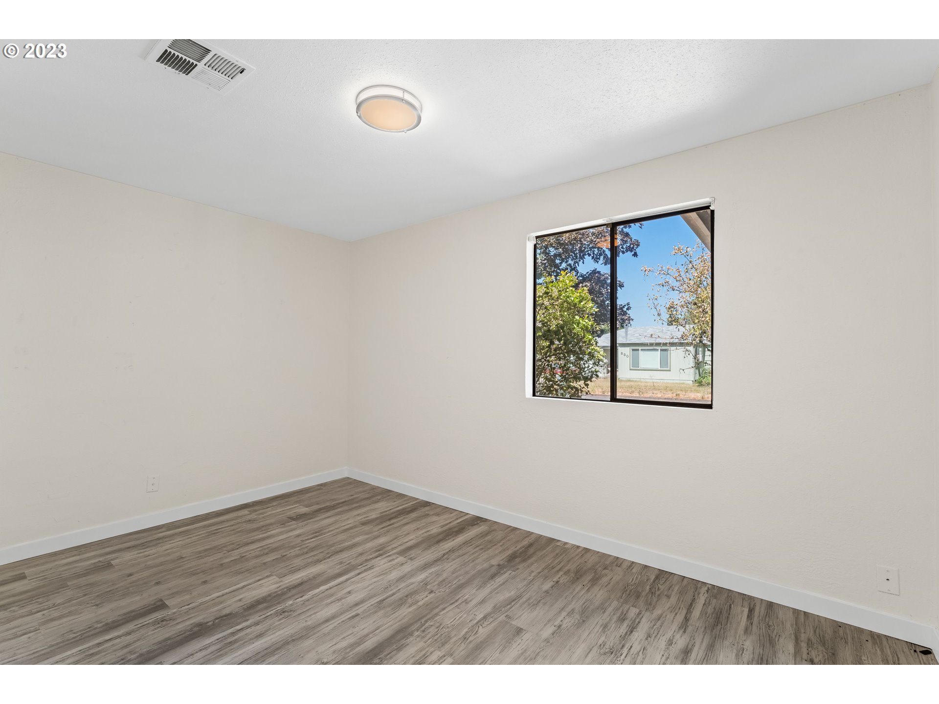 835 L Street Springfield, OR 97477 - Photo 25 of 40 an empty room with wooden floor and window