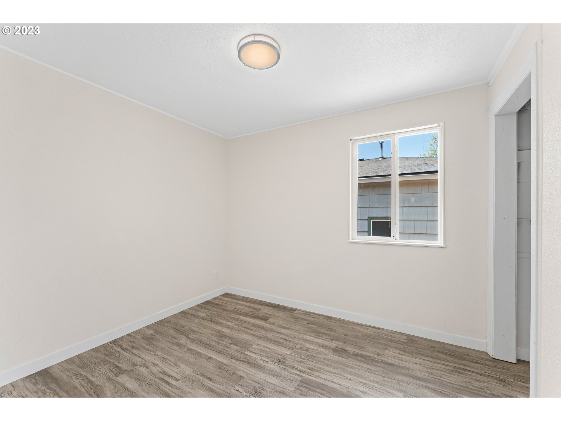 835 L Street Springfield, OR 97477 - Photo 28 of 40 a view of an empty room with wooden floor and a window