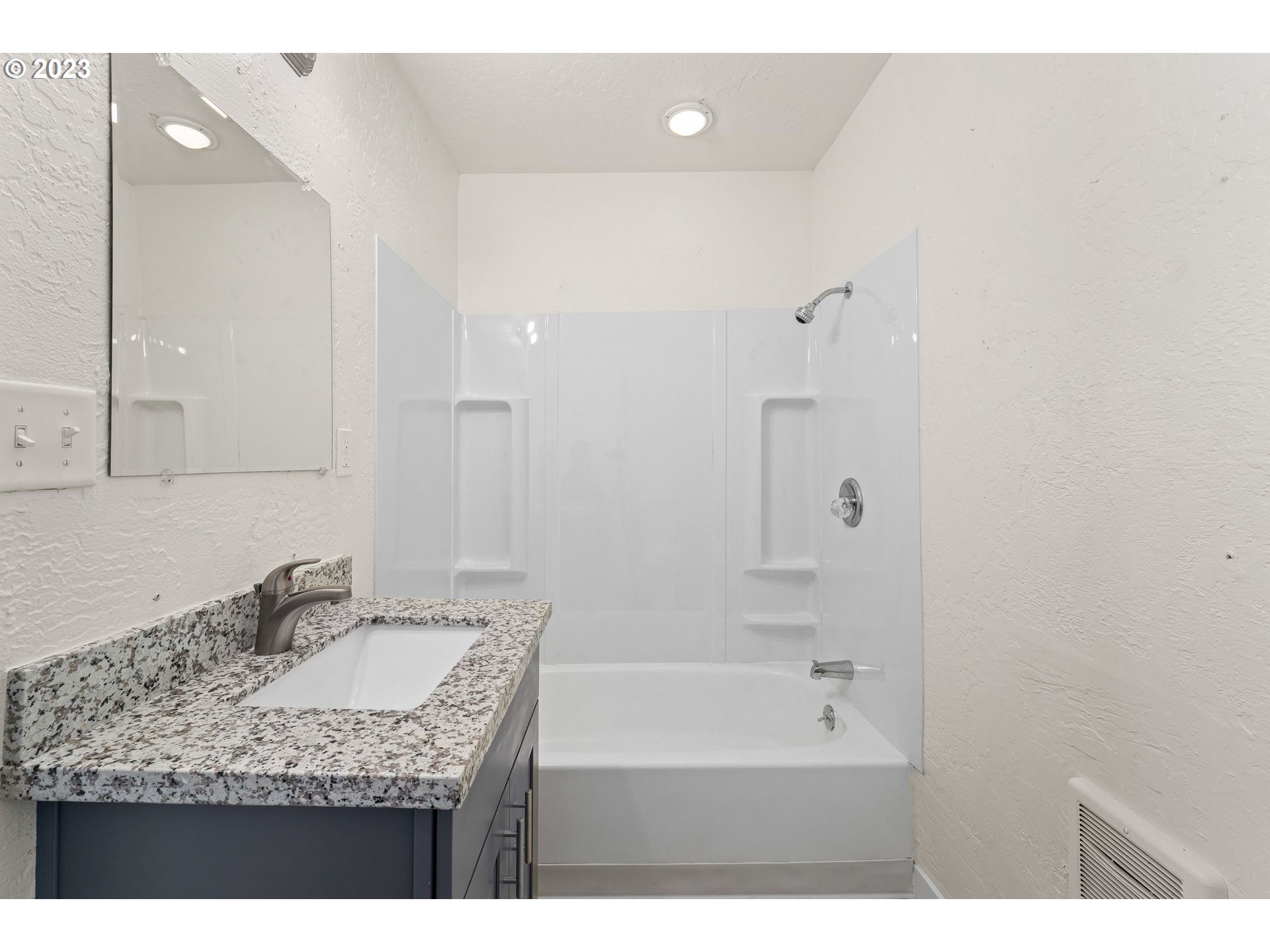 835 L Street Springfield, OR 97477 - Photo 31 of 40 a bathroom with a granite countertop sink a mirror and a bathtub