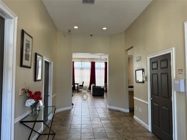 a view of a hallway with furniture and a refrigerator