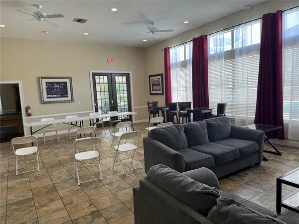 a living room with furniture and large windows