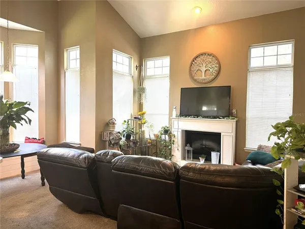 a living room with furniture a fireplace and a large window