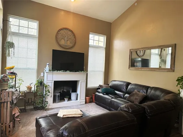 a living room with furniture a fireplace and a large mirror