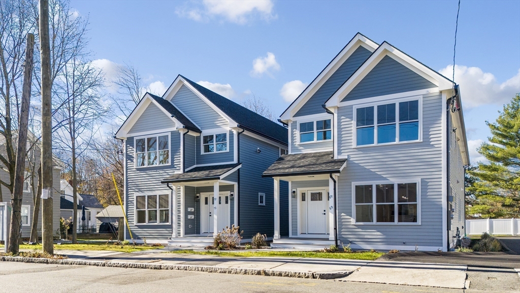 a view of a house with a yard and large tree