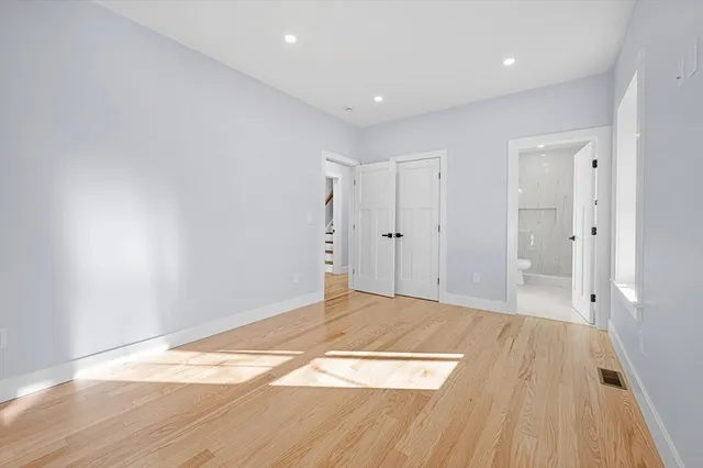 a view of an empty room with wooden floor