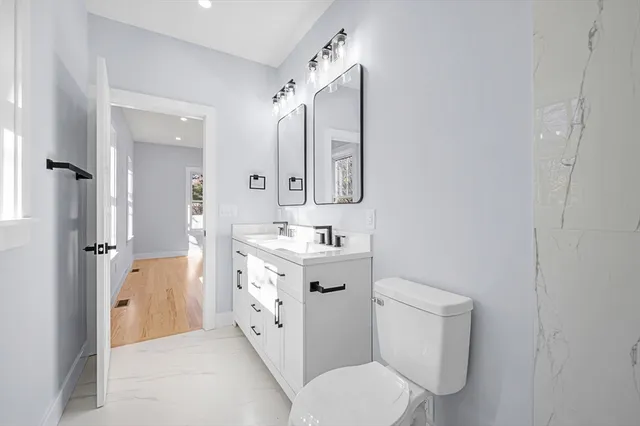 a spacious bathroom with a sink mirror vanity and toilet