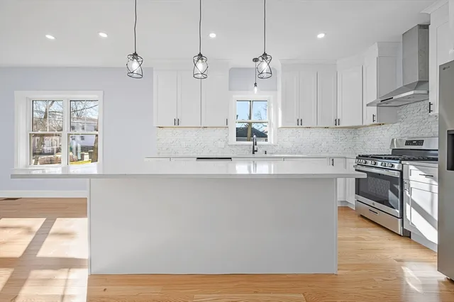 a kitchen with stainless steel appliances granite countertop a sink a stove a microwave a center island and cabinets