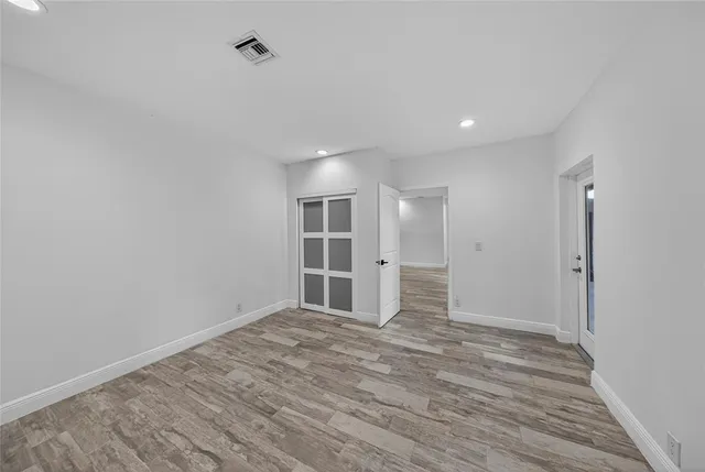 a view of empty room with wooden floor