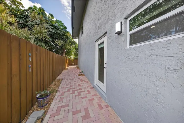 a kitchen with stainless steel appliances kitchen island granite countertop a refrigerator a stove top oven a sink dishwasher and white cabinets with wooden floor