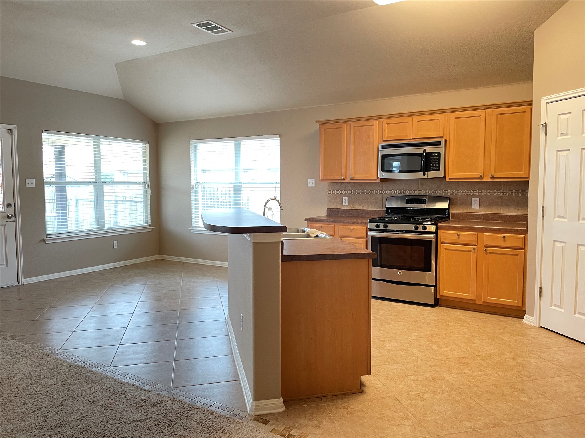 11713 Dunblane Way Austin, TX 78754 - Photo 11 of 22 Kitchen featuring light wood cabinetry, stainless steel oven/range, and a built-in microwave