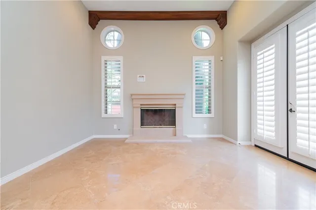 a view of an empty room with window and wooden floor
