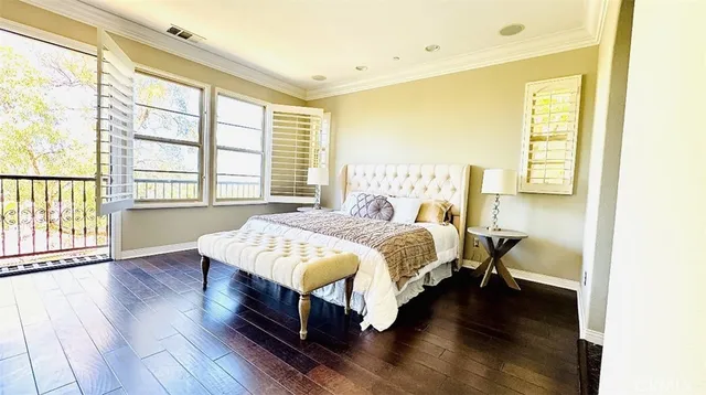 a bedroom with a bed lamp and a large window