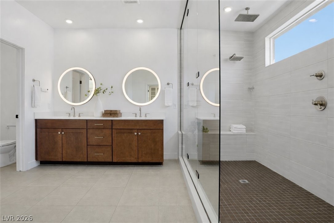 9725 Starlight Ridge Avenue Las Vegas, NV 89148 - Photo 30 of 47 This primary bathroom features a dual vanity, sleek shower, and ample natural light.