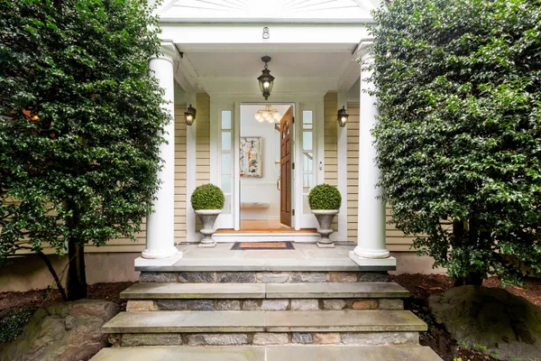 a view of a building with potted plants and large trees