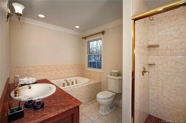 a bathroom with a granite countertop sink a toilet a mirror and shower