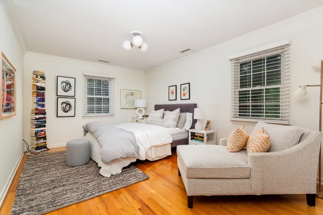 a spacious bedroom with a bed and wooden floor