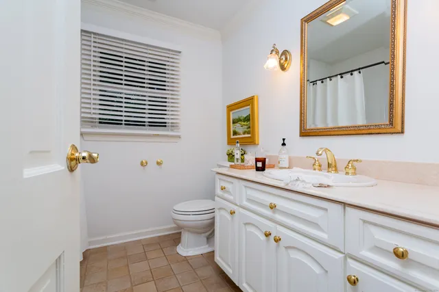 a bathroom with a granite countertop toilet sink and mirror